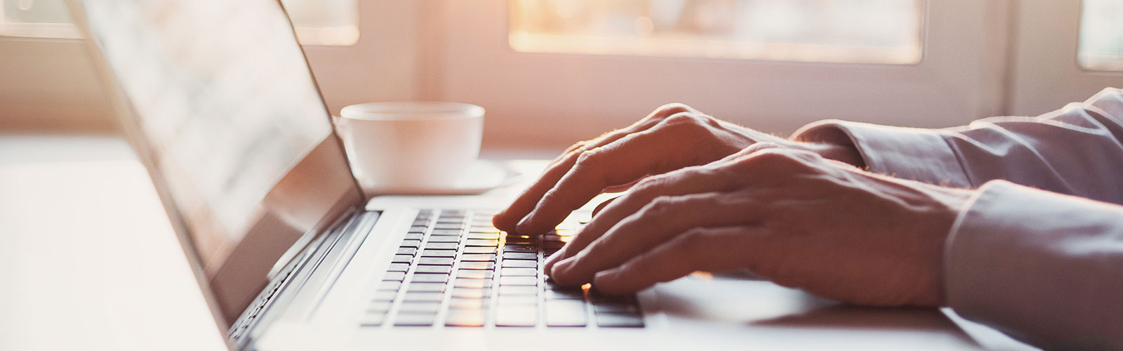 Hands typing on laptop