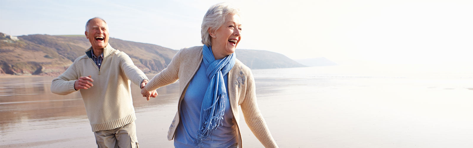 senior couple running on beach