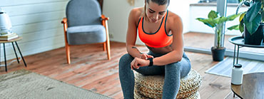 woman checks her fitness device on her wrist