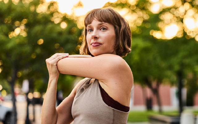 a woman stretching her arms before going on a run